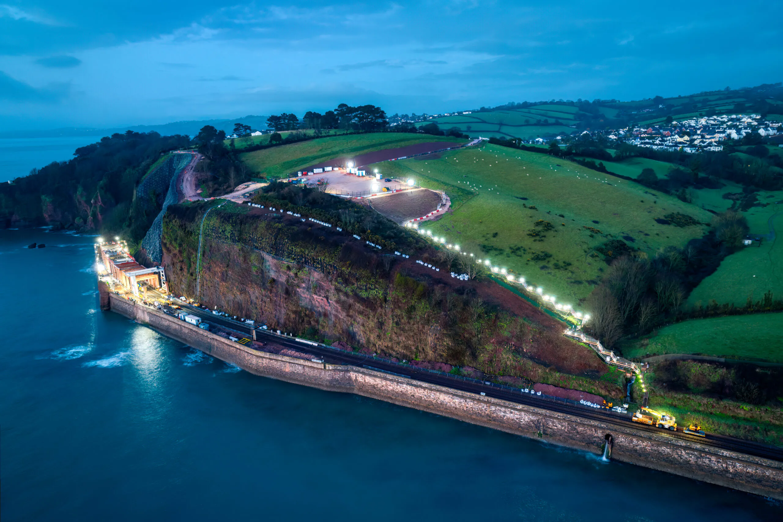 Aerial view of King's Cross railway station showing multiple train tracks leading into large arched roofs.