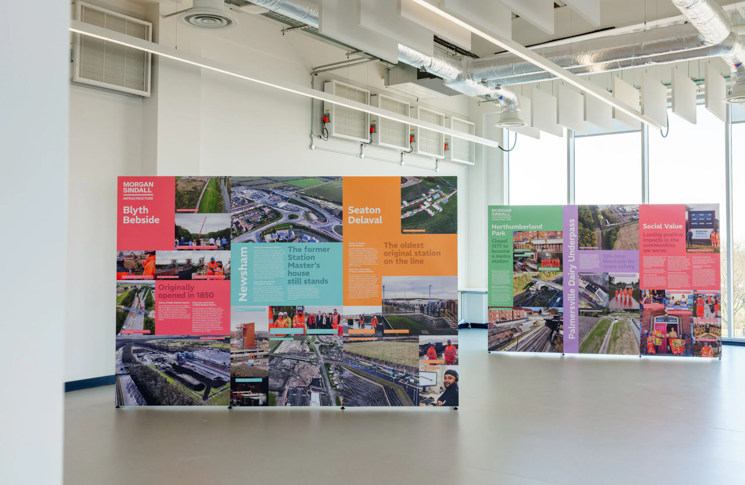 Indoor exhibition setup with colorful panels displaying information about Blyth Bebside, Seaton Delaval, Newsham, and the Northumberland Line, including social value highlights.