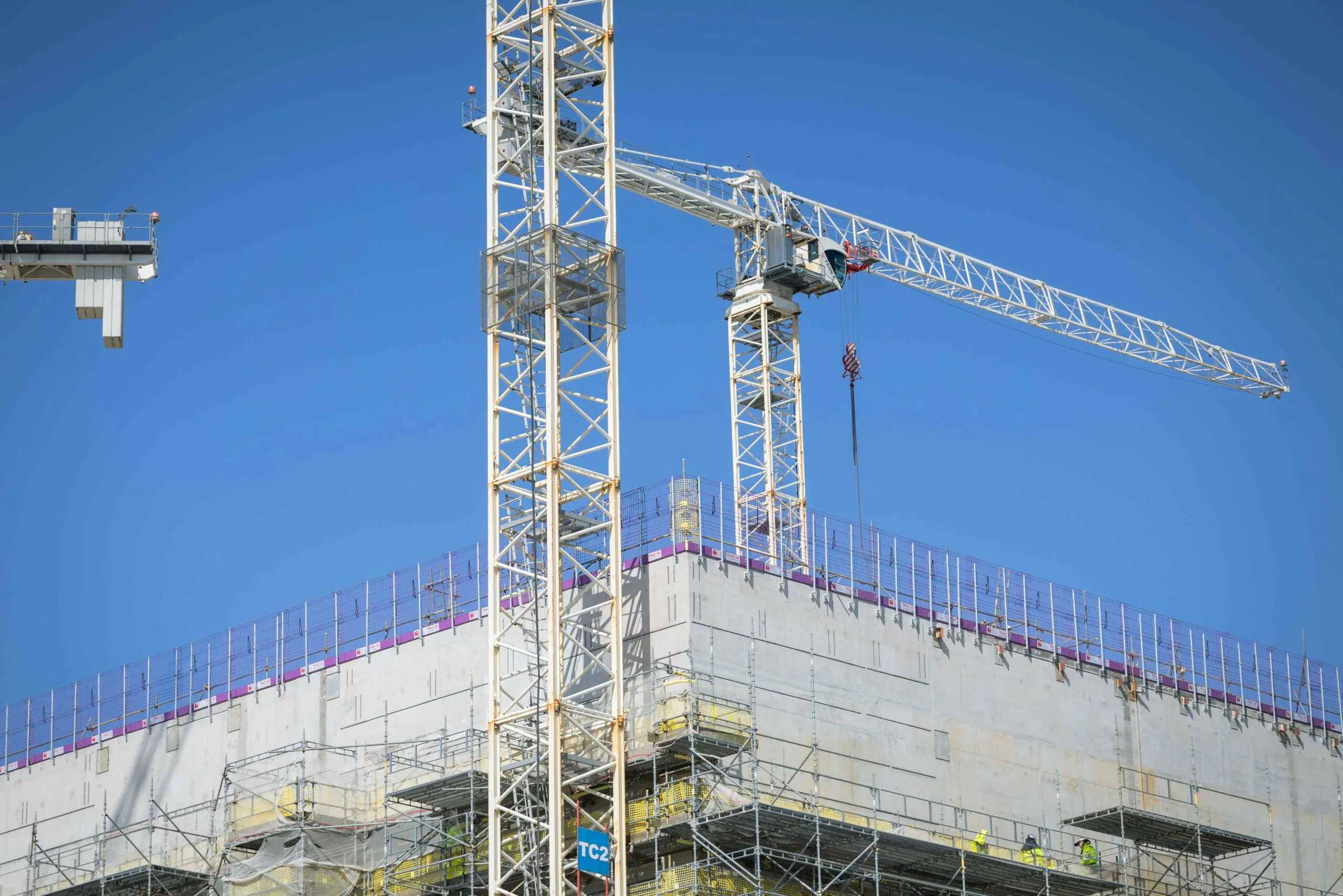 Close-up of scaffolding surrounding a tall structure under construction, highlighting the metal framework.