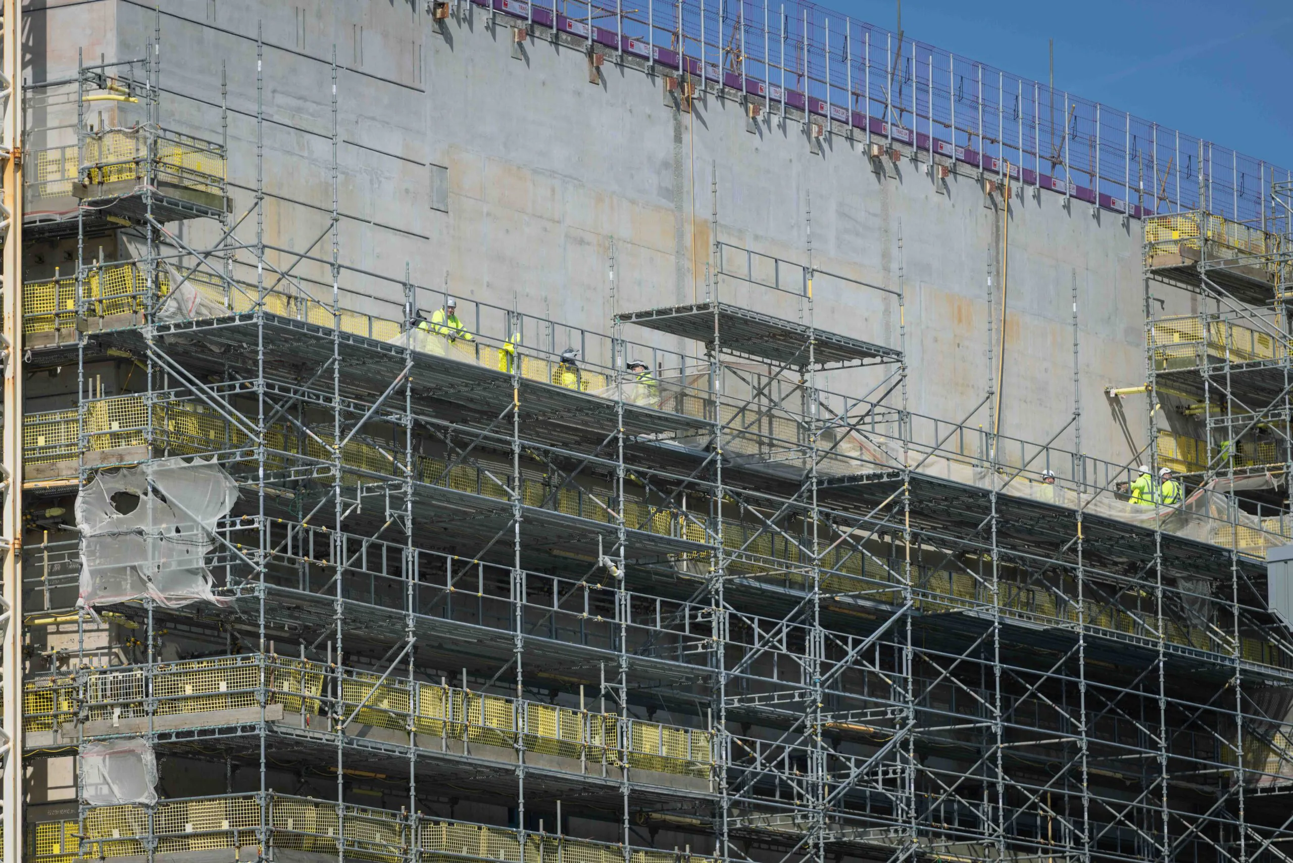 Detailed view of scaffolding and structural supports surrounding a high-rise construction site.