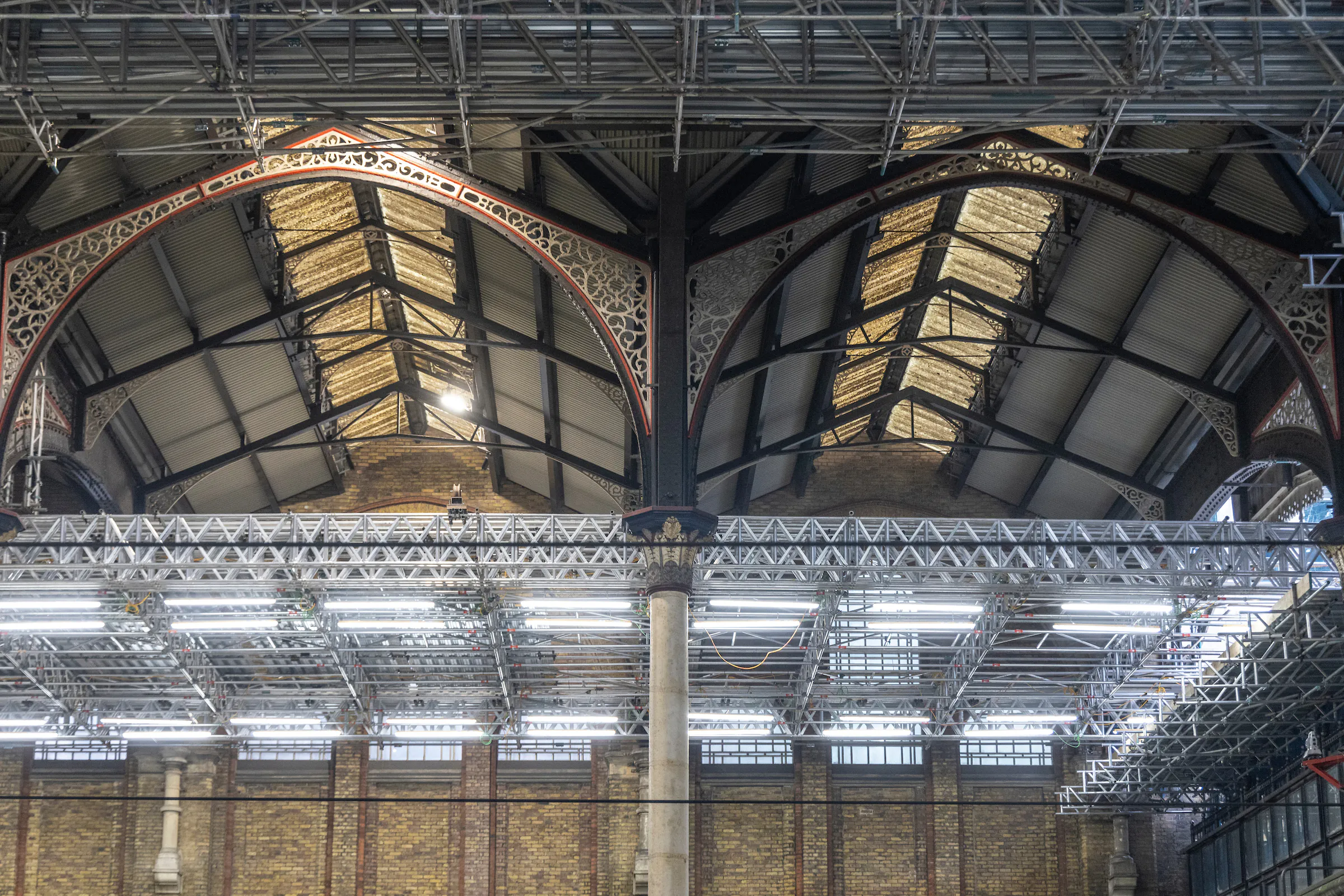 Interior view of Liverpool Street Station showing extensive scaffolding and construction activity.