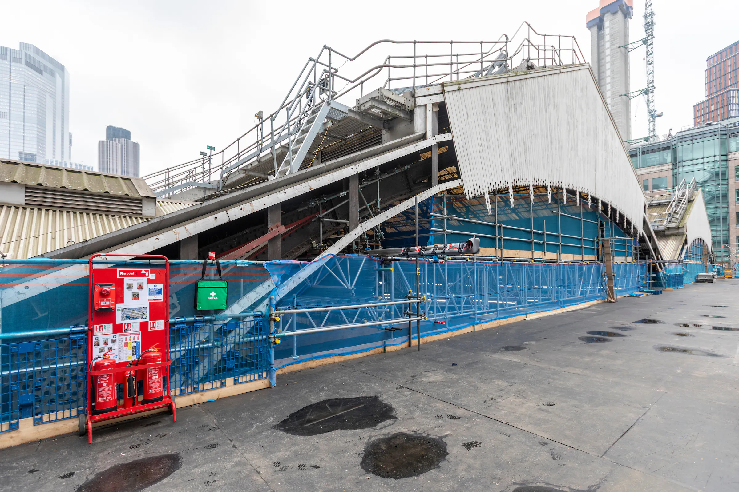 Interior view of Liverpool Street Station with scaffolding and construction materials.
