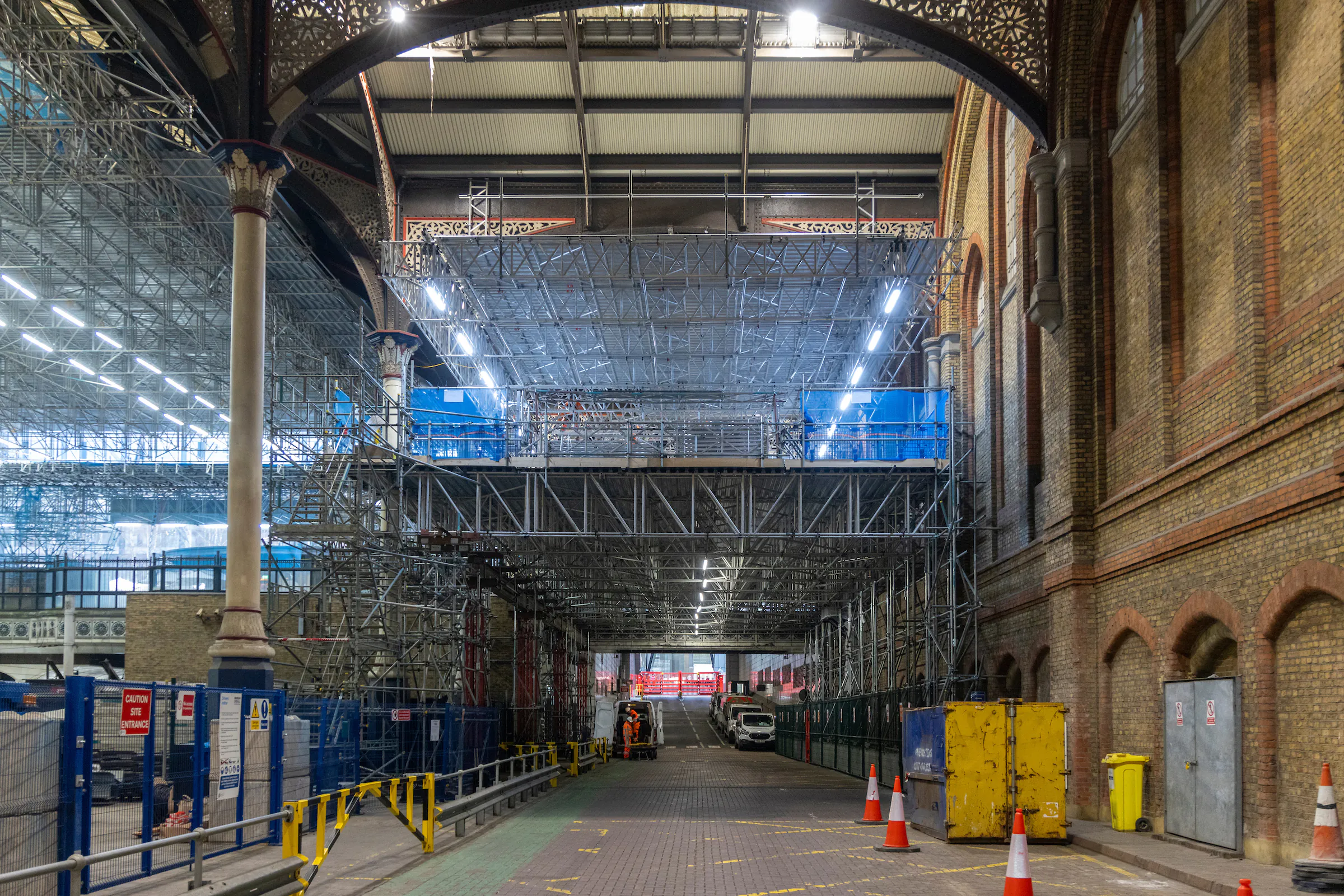 Exterior of a modern building undergoing renovation, surrounded by scaffolding.
