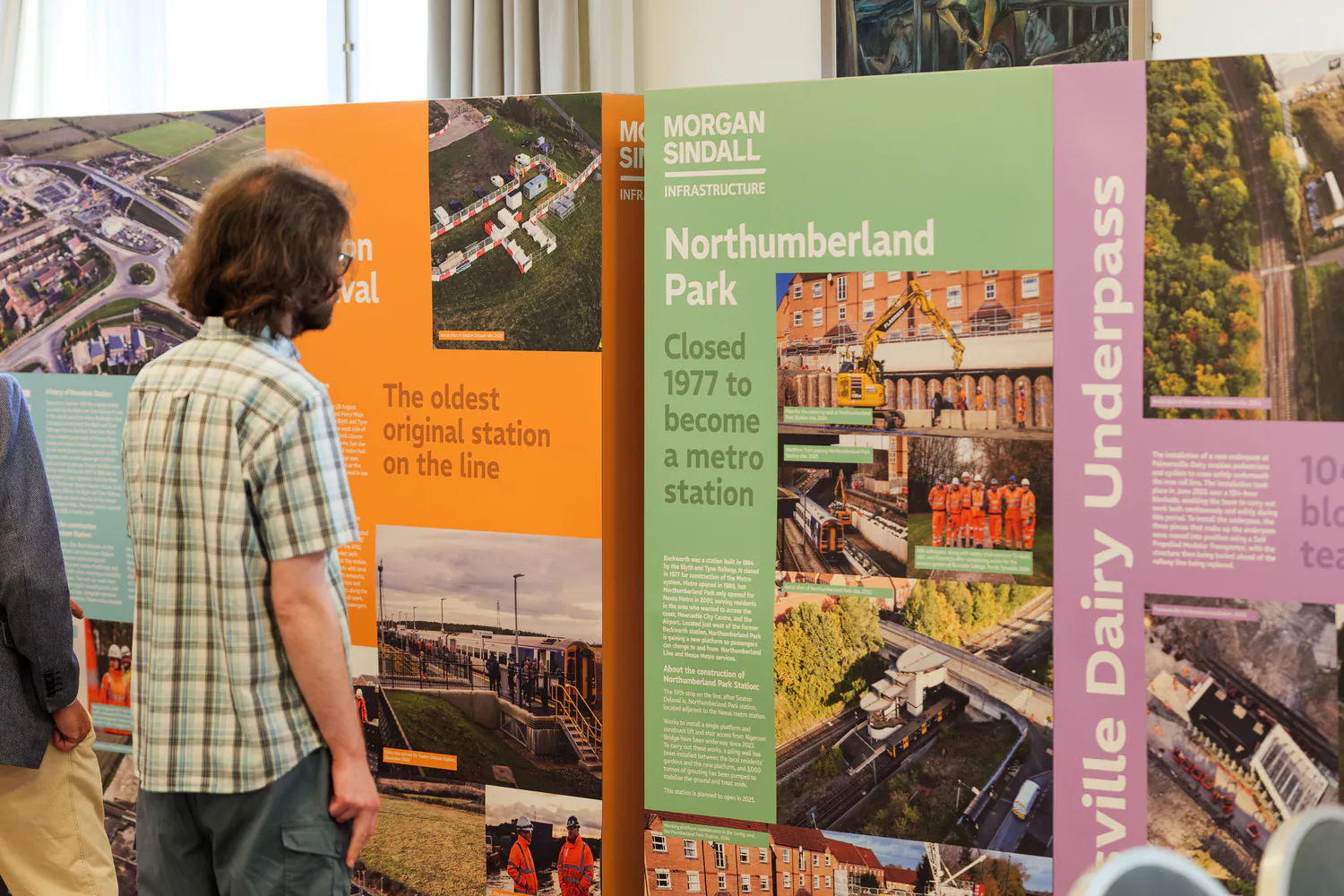 Group of people reviewing display boards detailing Morgan Sindall infrastructure projects, including historical context about Northumberland Park and local railway developments.
