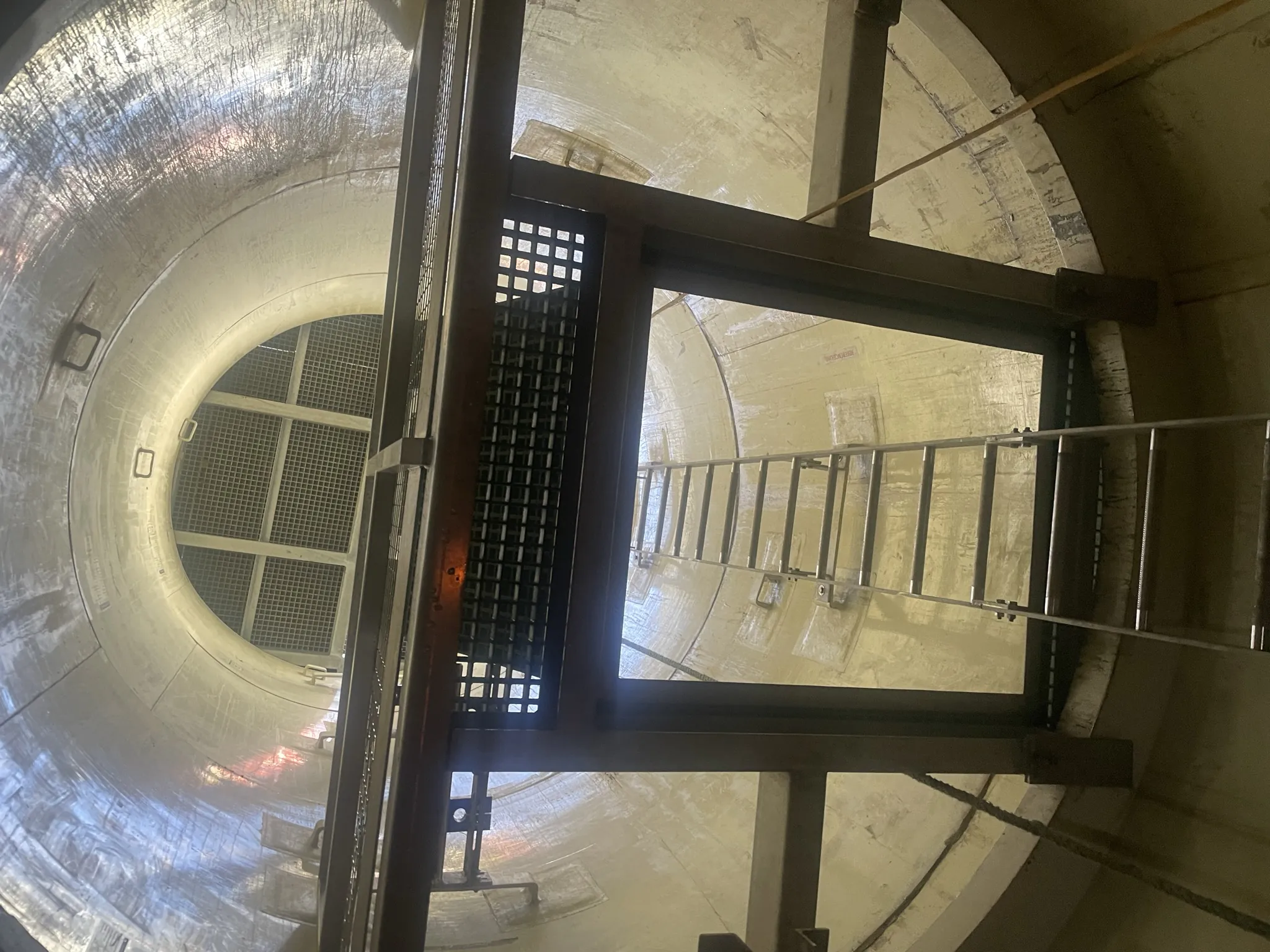 Wide view of a construction site in a hilly region with scaffolding and concrete structures under clear skies.