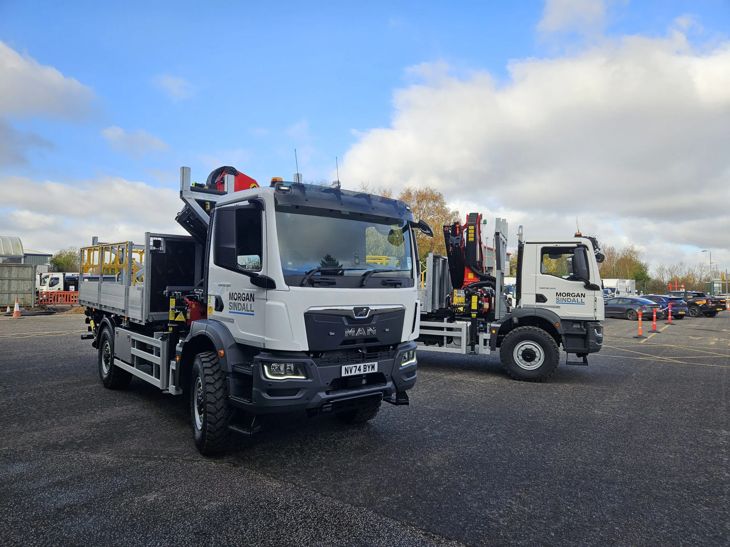 Two MAN grab wagons branded "Morgan Sindall" parked side-by-side in an outdoor lot under clear skies.