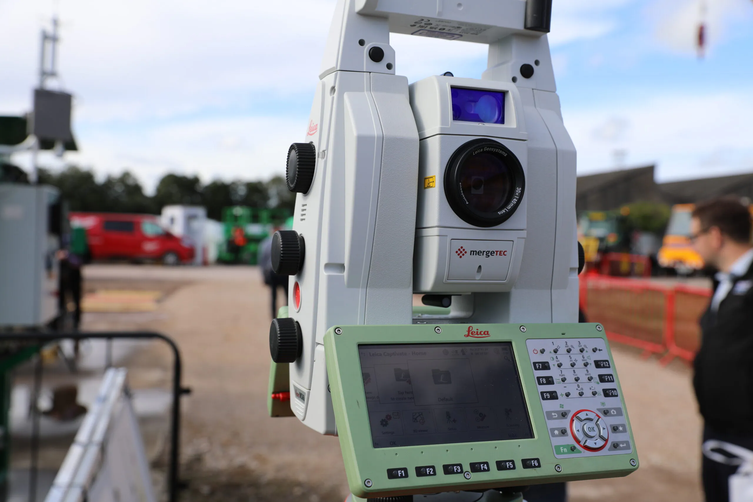Close-up of Leica Geosystems surveying equipment set up outdoors at an exhibition or trade show.