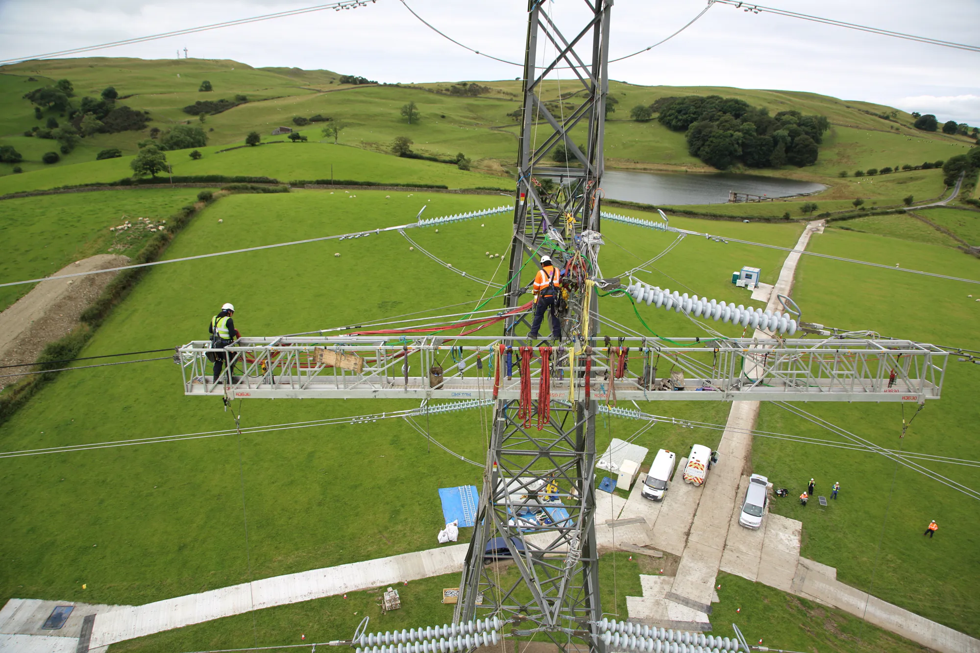 Elevated work platform used for overhead line maintenance, with workers in safety gear operating near electrical infrastructure.