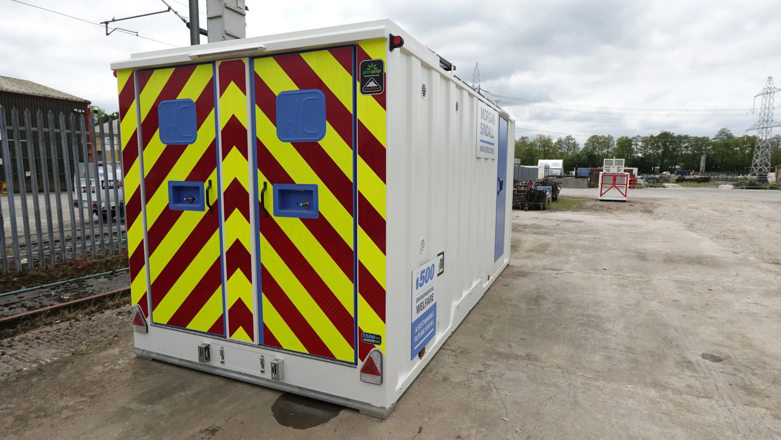 Side view of twin portable welfare units with Morgan Sindall branding, parked in an open area.
