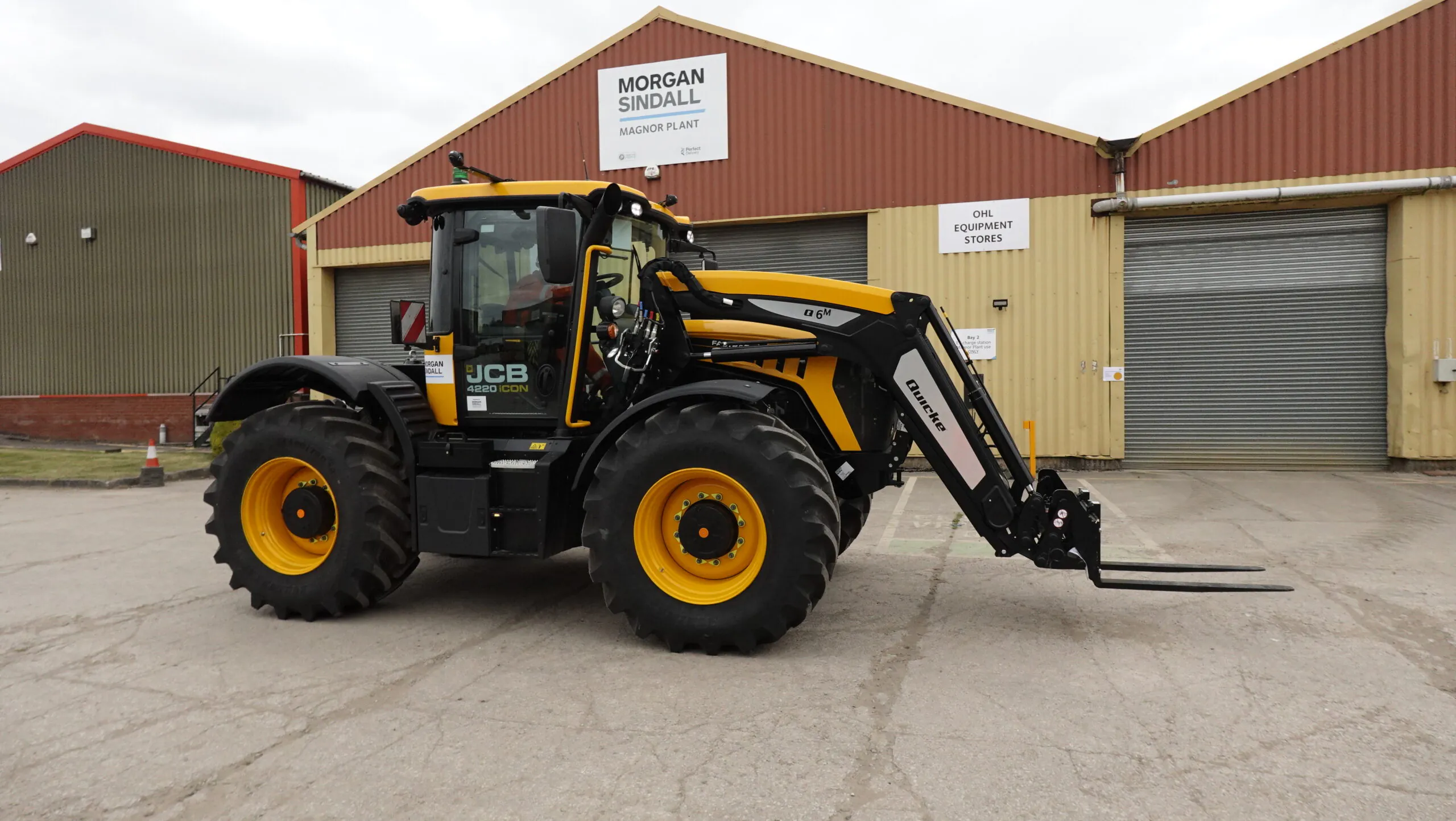 Large yellow JCB Fastrac tractor branded "Morgan Sindall," equipped for construction, parked in front of the Magnor Plant building.